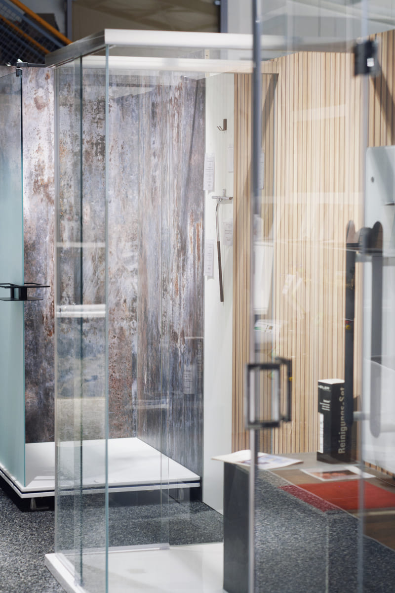 Moderne Duschkabine in einer Badausstellung mit Glaswänden und stilvoller Wandgestaltung